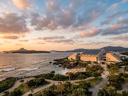 Fotorealistische Panoramaaufnahme von Churaumi-Aquarium Okinawa in Motobu Japan, warmes Abendlicht auf Wahrzeichen - Foto: THN