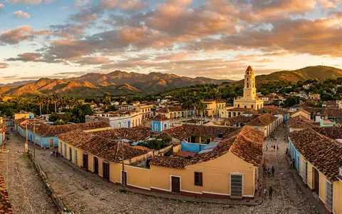 Fotorealistische Panoramaaufnahme von Trinidad Kuba Altstadt in Trinidad Kuba, warmes Abendlicht auf Wahrzeichen - Foto: THN