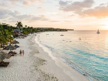 Editorialbild im Reisemagazin-Stil vom Wahrzeichen Seven Mile Beach in Negril Jamaika, ausgewogene Bildgestaltung und natuerliches - Foto: THN