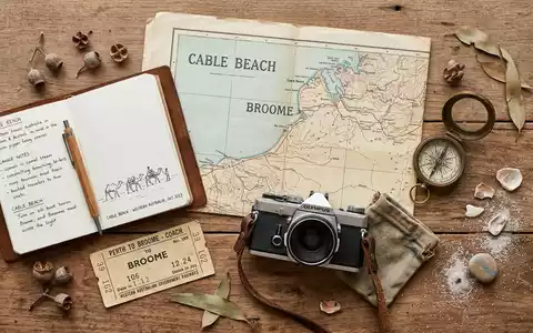 Flatlay-Reise-Arrangement rund um Cable Beach Broome in Broome Australien, Karte Kompass Kamera und generische Reiserequisiten - Foto: THN