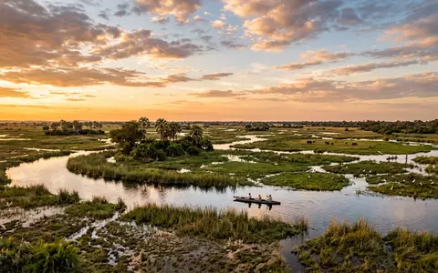 Fotorealistische Panoramaaufnahme von Okavango-Delta in Maun Botswana, warmes Abendlicht auf Wahrzeichen im Reisemotiv - Foto: THN