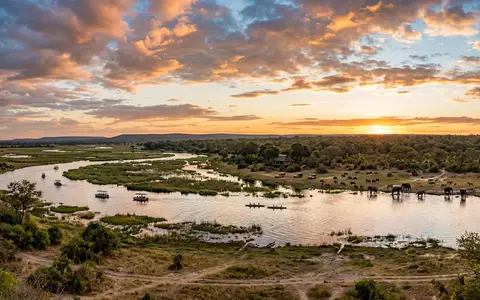 Fotorealistische Panoramaaufnahme von Chobe-Nationalpark in Kasane Botswana, warmes Abendlicht auf Wahrzeichen im Reisemotiv - Foto: THN