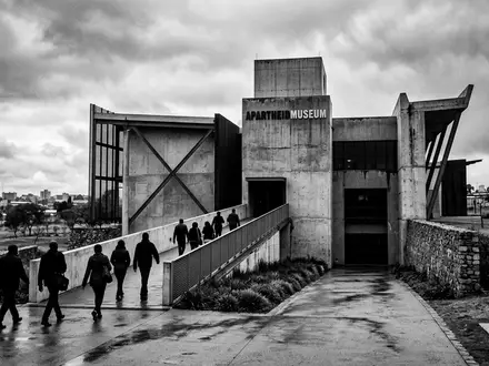 Schwarzweiss-Reportagebild vom Wahrzeichen Apartheid Museum Johannesburg in Johannesburg Sudafrika, dokumentarische Reisefotografie mit starken Kontrasten - Foto: THN