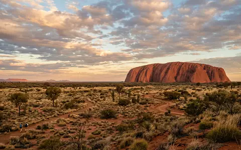 Editorialbild im Reisemagazin-Stil vom Wahrzeichen Uluru in Yulara Australien, ausgewogene Bildgestaltung und natuerliches Umgebungslicht - Foto: THN