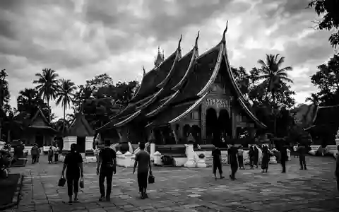 Schwarzweiss-Reportagebild vom Wahrzeichen Wat Xieng Thong in Luang Prabang Laos, dokumentarische Reisefotografie mit starken Kontrasten - Foto: THN