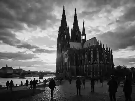 Schwarzweiss-Reportagebild vom Wahrzeichen Kölner Dom in Köln Deutschland, dokumentarische Reisefotografie mit starken Kontrasten - Foto: THN