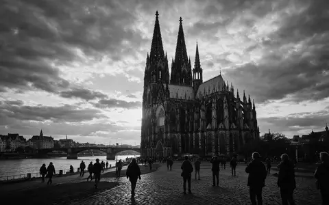 Schwarzweiss-Reportagebild vom Wahrzeichen Kölner Dom in Köln Deutschland, dokumentarische Reisefotografie mit starken Kontrasten - Foto: THN