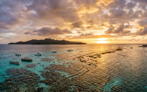 Fotorealistische Panoramaaufnahme von Utila-Riff in Utila Honduras, warmes Abendlicht auf Wahrzeichen im Reisemotiv - Foto: THN