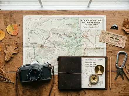 Flatlay-Reise-Arrangement rund um Rocky-Mountain-Nationalpark in Estes Park USA, Karte Kompass Kamera und generische Reiserequisiten - Foto: THN