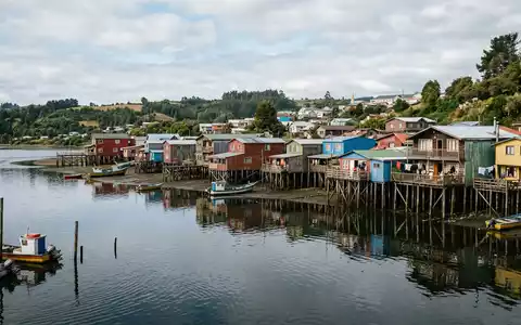 Editorialbild im Reisemagazin-Stil vom Wahrzeichen Chiloe Palafitos in Castro Chile, ausgewogene Bildgestaltung und natuerliches Umgebungslicht - Foto: THN