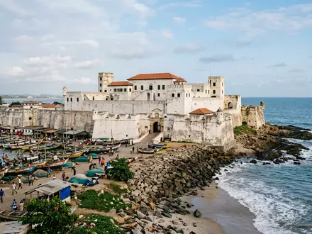 Editorialbild im Reisemagazin-Stil vom Wahrzeichen Elmina Castle in Elmina Ghana, ausgewogene Bildgestaltung und natuerliches Umgebungslicht - Foto: THN