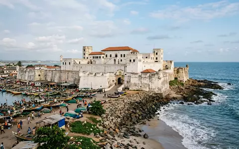 Editorialbild im Reisemagazin-Stil vom Wahrzeichen Elmina Castle in Elmina Ghana, ausgewogene Bildgestaltung und natuerliches Umgebungslicht - Foto: THN