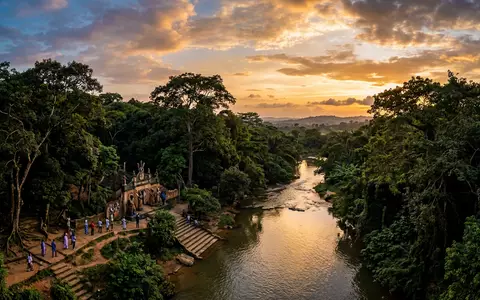 Fotorealistische Panoramaaufnahme von Osun-Osogbo Sacred Grove in Osogbo Nigeria, warmes Abendlicht auf Wahrzeichen - Foto: THN