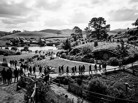 Schwarzweiss-Reportagebild vom Wahrzeichen Hobbiton Filmset in Matamata Neuseeland, dokumentarische Reisefotografie mit starken Kontrasten - Foto: THN