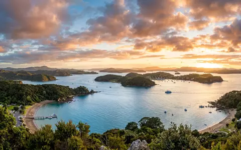 Fotorealistische Panoramaaufnahme von Bay of Islands in Paihia Neuseeland, warmes Abendlicht auf Wahrzeichen - Foto: THN