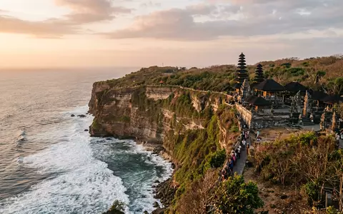 Editorialbild im Reisemagazin-Stil vom Wahrzeichen Uluwatu-Tempel Bali in Pecatu Indonesien, ausgewogene Bildgestaltung und natuerliches Umgebungslicht - Foto: THN