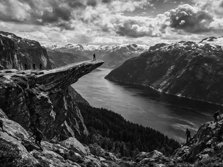 Schwarzweiss-Reportagebild vom Wahrzeichen Trolltunga in Ullensvang Norwegen, dokumentarische Reisefotografie mit starken Kontrasten - Foto: THN