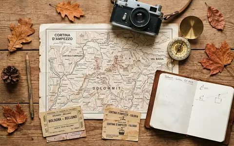 Flatlay-Reise-Arrangement rund um Dolomiten in Cortina d'Ampezzo Italien, Karte Kompass Kamera und generische Reiserequisiten - Foto: THN
