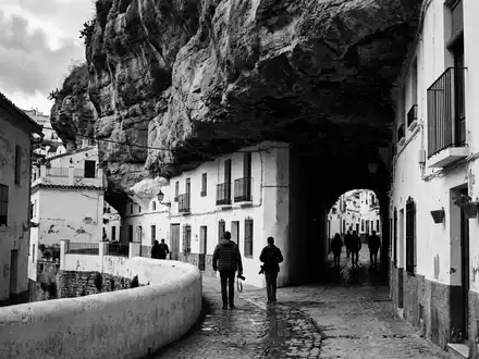 Schwarzweiss-Reportagebild vom Wahrzeichen Setenil de las Bodegas in Setenil Spanien, dokumentarische Reisefotografie mit starken Kontrasten - Foto: THN