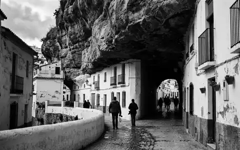 Schwarzweiss-Reportagebild vom Wahrzeichen Setenil de las Bodegas in Setenil Spanien, dokumentarische Reisefotografie mit starken Kontrasten - Foto: THN