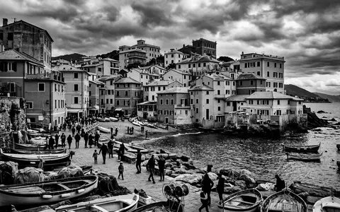 Schwarzweiss-Reportagebild vom Wahrzeichen Boccadasse Genua in Genua Italien, dokumentarische Reisefotografie mit starken Kontrasten - Foto: THN