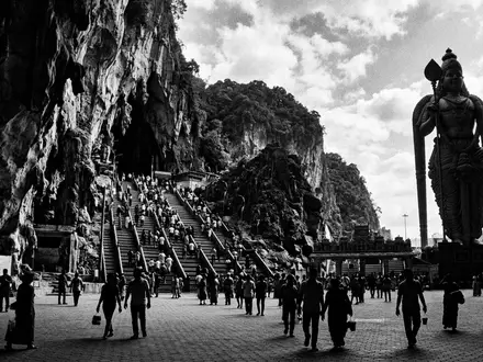 Schwarzweiss-Reportagebild vom Wahrzeichen Batu Caves in Gombak Malaysia, dokumentarische Reisefotografie mit starken Kontrasten - Foto: THN