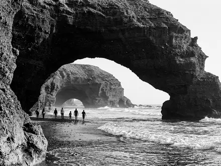 Schwarzweiss-Reportagebild vom Wahrzeichen Legzira-Strand in Sidi Ifni Marokko, dokumentarische Reisefotografie mit starken Kontrasten - Foto: THN