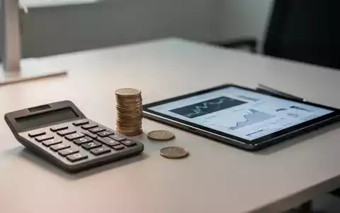 Ein Schreibtisch mit einem Taschenrechner und Euromünzen, die die finanzielle Situation und Zuverdienstmöglichkeiten symbolisieren. - Foto: über boerse-global.de