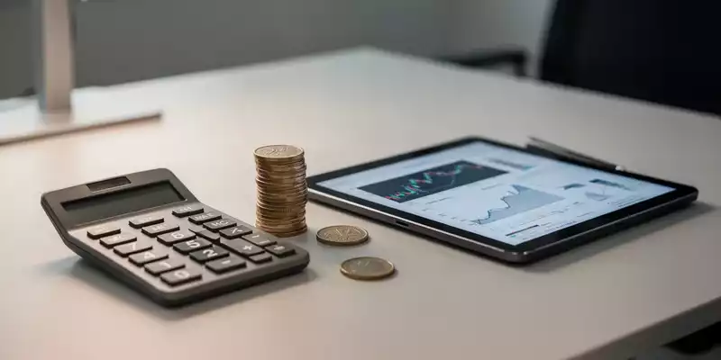 Ein Schreibtisch mit einem Taschenrechner und Euromünzen, die die finanzielle Situation und Zuverdienstmöglichkeiten symbolisieren. - Foto: über boerse-global.de