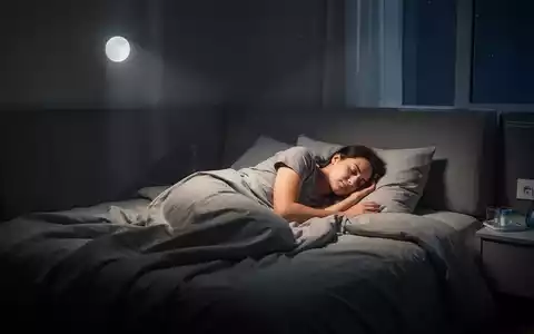 Eine schlafende Person in einem modern eingerichteten Schlafzimmer bei sanftem Mondlicht. - Foto: über boerse-global.de