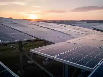 Reihen von Solarmodulen in einem Solarpark während des Sonnenuntergangs. - Foto: über boerse-global.de