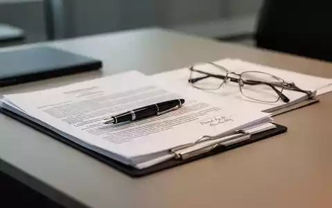 Rechtliche Unterlagen und eine Brille auf einem Schreibtisch als Symbol für Arbeitsrecht und Abfindungsansprüche. - Foto: über boerse-global.de