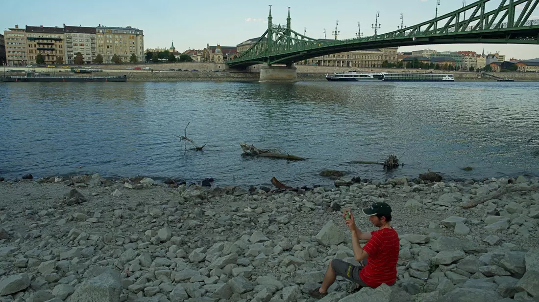 Unter der Freiheitsbrücke lässt sich's nun im Trockenen sitzen.  - Bild: Bela Szandelszky/AP/dpa