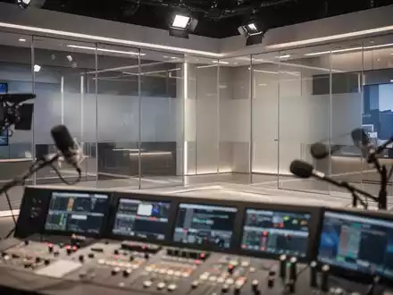 Modernes Fernseh- und Rundfunkstudio mit technischer Ausstattung und Mikrofonen in professioneller Lichtstimmung. - Foto: ĂĽber boerse-global.de