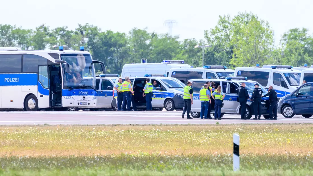 Zahlreiche Einsatzwagen der Polizei sind an der «Nordpiste» des Flughafens Leipzig/Halle im Einsatz. - Bild: Hendrik Schmidt/dpa