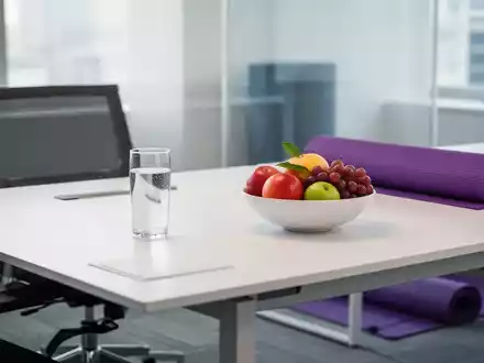 Ein heller, moderner Arbeitsplatz mit frischem Obst und einer Yogamatte als Symbol für Gesundheit und Vereinbarkeit. - Foto: über boerse-global.de