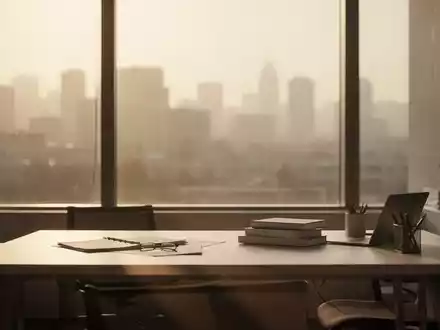 Ein minimalistischer Büroarbeitsplatz mit Blick auf eine verschwommene, hitzeflimmernde Stadtlandschaft bei warmem Licht. - Foto: über boerse-global.de