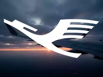 Ein modernes Flugzeugflügel-Profil vor einem bewölkten Sonnenaufgang, das die Luftfahrtbranche symbolisiert. - Foto: über boerse-global.de