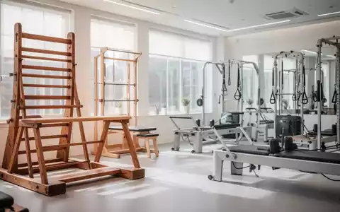 Kombination aus historischen Turngeräten aus Holz und modernen Pilates-Geräten in einem hellen Fitnessstudio. - Foto: über boerse-global.de