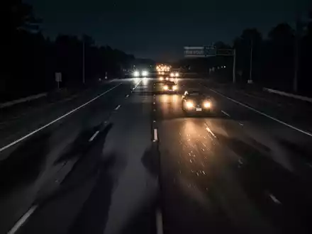 Dunkle Autobahn bei Nacht mit verschwommenen Scheinwerfern, die eine bedrohliche Atmosphäre im Kontext von Kriminalität vermittelt. - Foto: über boerse-global.de