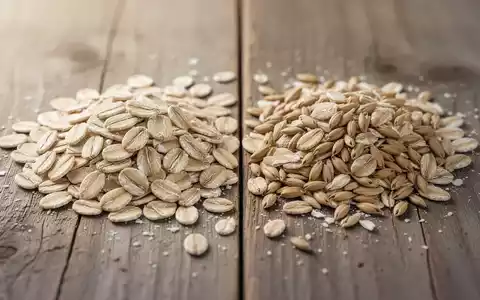Nahaufnahme von Hafer- und Dinkelflocken auf einem Holztisch, die sich in ihrer Struktur und Farbe leicht unterscheiden. - Foto: über boerse-global.de