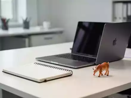 Moderner Schreibtisch mit Laptop und Spielzeug, der die Vereinbarkeit von Beruf und Familie symbolisiert. - Foto: über boerse-global.de