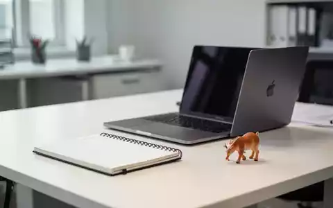 Moderner Schreibtisch mit Laptop und Spielzeug, der die Vereinbarkeit von Beruf und Familie symbolisiert. - Foto: über boerse-global.de