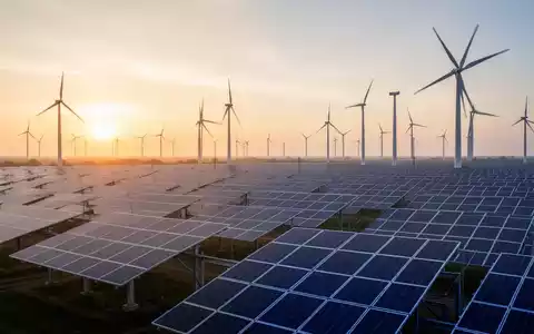 Moderne Solarparks und Windkraftanlagen im goldenen Licht des Sonnenaufgangs. - Foto: über boerse-global.de