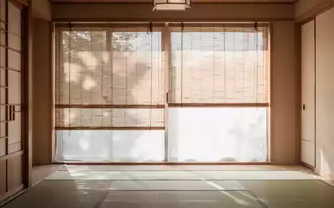 Ein minimalistisch gestalteter japanischer Wohnraum mit hellen Holzelementen und halb herabgelassenen Bambusrollos. - Foto: über boerse-global.de