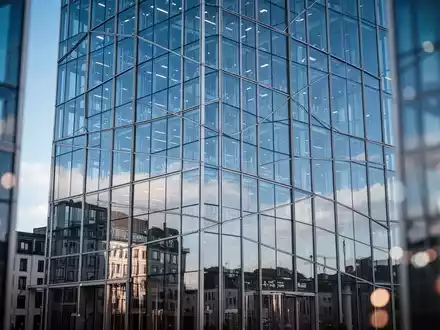 Moderne Glasfassade eines Finanzgebäudes in Frankfurt vor blauem Himmel. - Foto: über boerse-global.de