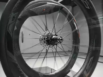 Nahaufnahme eines aerodynamischen Carbon-Fahrradlaufrads in einem Windkanal zur Optimierung der sportlichen Effizienz. - Foto: über boerse-global.de