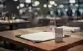 Ein leeres Menü auf einem Holztisch in einem modernen Restaurant als Symbol für die Mehrwertsteuerdebatte in der Gastronomie. - Foto: über boerse-global.de