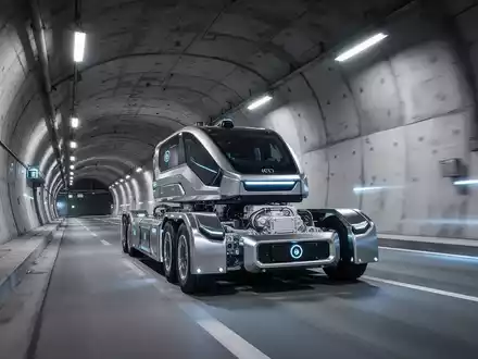 Ein autonomer Liner Truck fährt durch einen modernen Tunnel und transportiert schwere Betonelemente. - Foto: über boerse-global.de