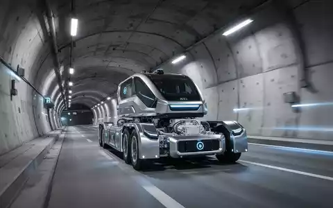 Ein autonomer Liner Truck fährt durch einen modernen Tunnel und transportiert schwere Betonelemente. - Foto: über boerse-global.de
